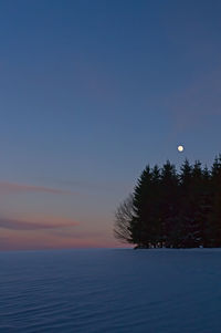 Scenic view of snow against sky at sunset