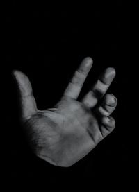 Close-up of human hand against black background