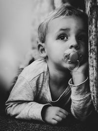 Close-up of cute boy with pacifier in mouth