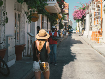 Rear view of women walking on street in city