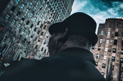 Low angle view of man standing by buildings in city