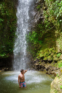 Man standing in waterfall