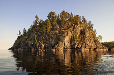 Scenic view of rock formation in sea against clear sky