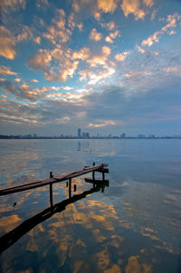 Pier over sea against sky during sunset