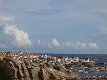 Panoramic view of sea and buildings in town against sky