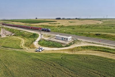 High angle view of road amidst field against sky