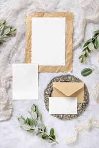 Wedding stationery set with envelope on a marble table with eucalyptus branches