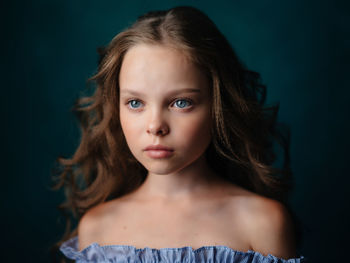Portrait of cute girl against black background