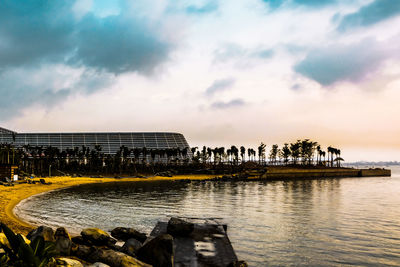 View of buildings in sea against cloudy sky