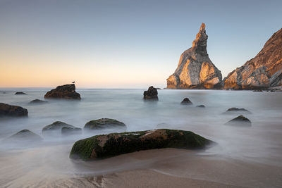 Scenic view of rocks in sea against sky