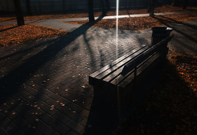 High angle view of empty bench on sidewalk