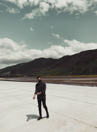 Full length of man standing on mountain against sky