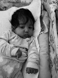 High angle view of cute baby girl lying in crib