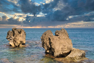 Rocks on sea shore against sky