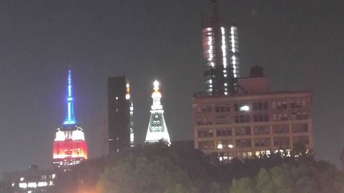 Illuminated buildings against sky at night