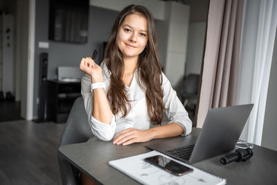 Young woman using laptop at table