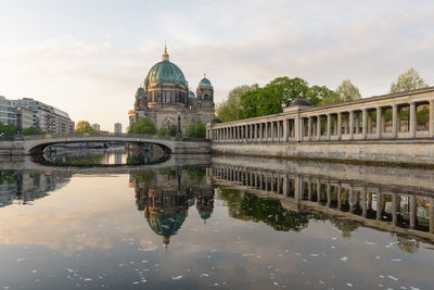 Arch bridge over river against buildings