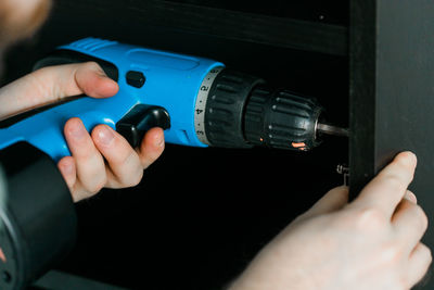 Cropped hands of man repairing machine