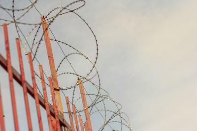 Metal fence with barbed wire on top.