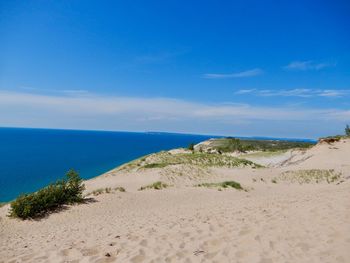 Scenic view of beach against blue sky