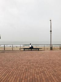Rear view of people looking at sea against sky