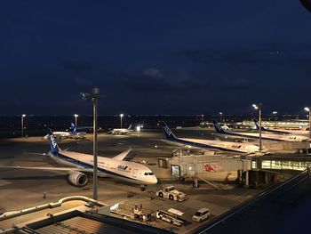 Airplane on runway against sky at night