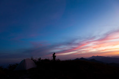 Scenic view of silhouette mountains against sky at sunset