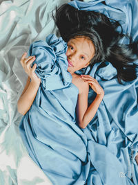 High angle portrait of cute baby lying on bed