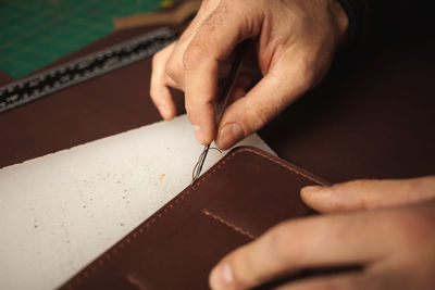 Tanner makes leather wallet, professional craftsman, closeup, business. handiwork.