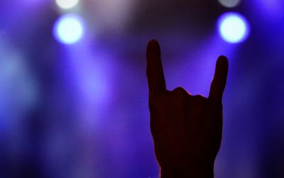 Close-up of human hand against purple blue sky