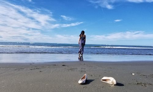 Boy on beach against sky