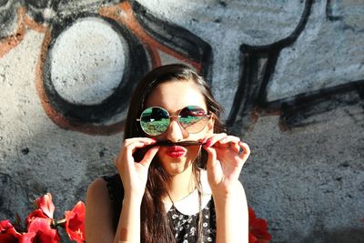 Portrait of smiling young woman wearing sunglasses