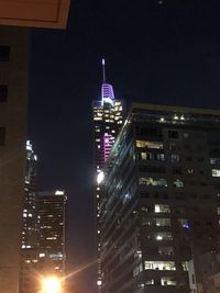 Low angle view of illuminated buildings against sky at night