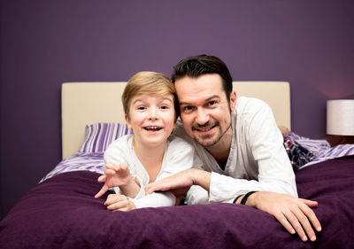 Portrait of father and son on bed