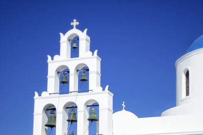 Low angle view of bell tower against blue sky