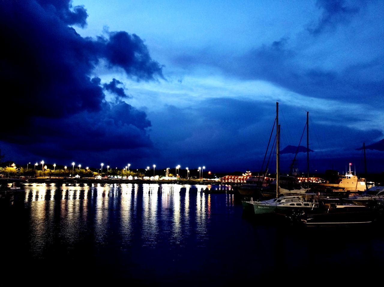water, sky, cloud, nautical vessel, dusk, reflection, night, evening, transportation, sea, nature, sailboat, mode of transportation, illuminated, architecture, harbor, no people, beauty in nature, cityscape, travel destinations, horizon, moored, ship, city, marina, scenics - nature, outdoors, travel, built structure, dock, tranquility, dramatic sky, building exterior, sunset, yacht, sailing, blue