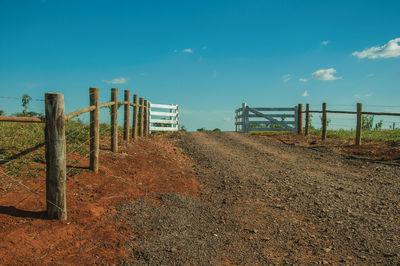 Wooden farm gate and cattle guard in the middle of barbed wire fence, near pardinho. brasil.