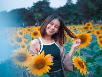 Portrait of smiling young woman with yellow flower