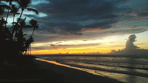 Scenic view of sea against cloudy sky during sunset