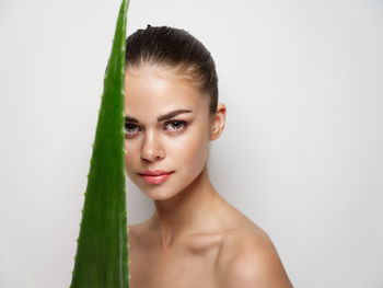 Portrait of young woman against white background