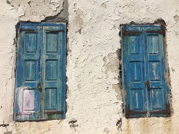 Closed blue windows of abandoned house