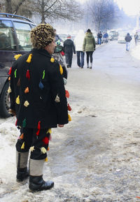 Rear view of people walking in snow