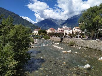 Scenic view of townscape by mountains against sky