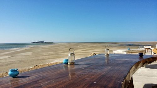 Scenic view of beach against clear blue sky