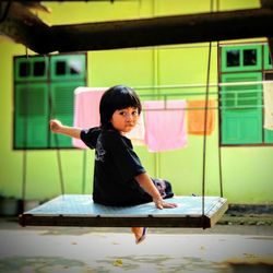 Portrait of cute girl standing on table