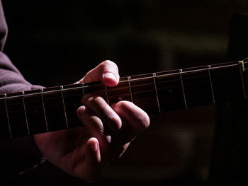 Close-up of hand playing guitar