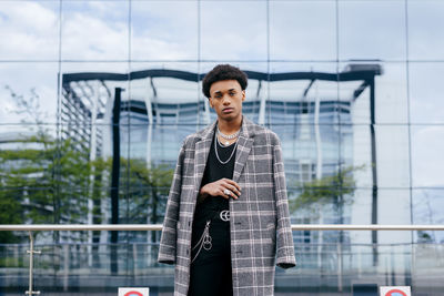 Portrait of young man standing against railing