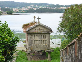 Built structure by lake against trees and plants