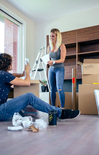 Full length of woman sitting on floor at home