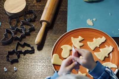 High angle view of cropped hands of man playing with toy blocks on table